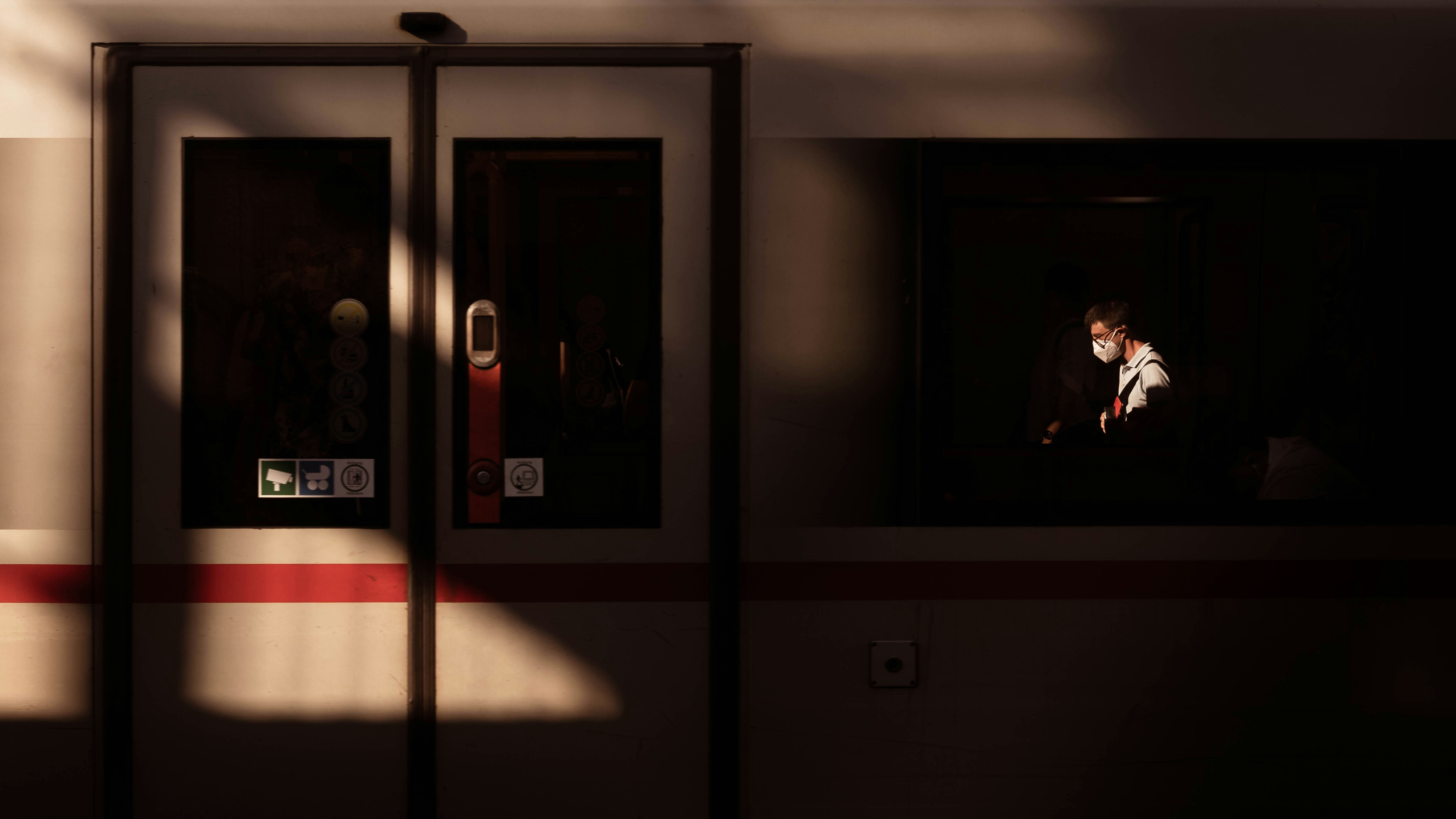 Person illuminated through train window at night.