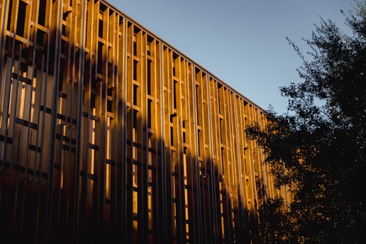 Modern building facade with warm sunset light and shadows.