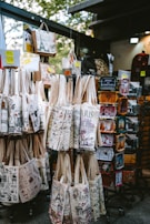 Souvenir tote bags and tins displayed at a market stall.