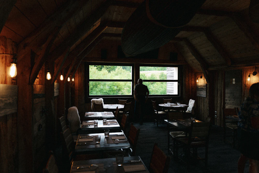 Salle à manger rustique et chaleureuse aux grandes fenêtres