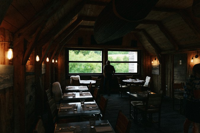 A restaurant interior with large windows looking outside, similar to the indoor and patio layout planned for the Sunset Road location