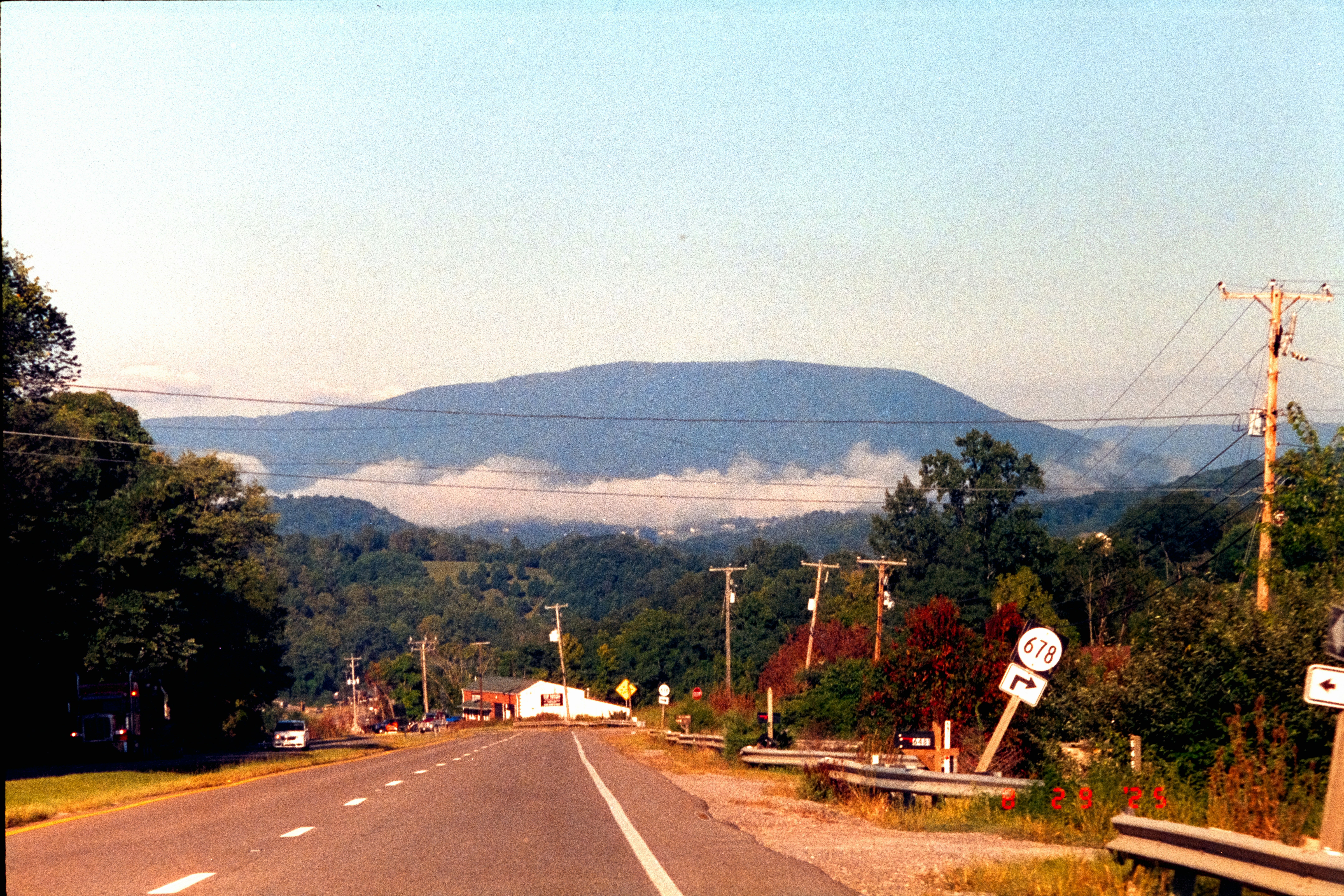 Mountain range with low clouds and trees.