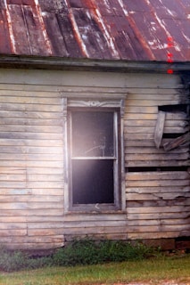 Dilapidated wooden house with a rusty tin roof.