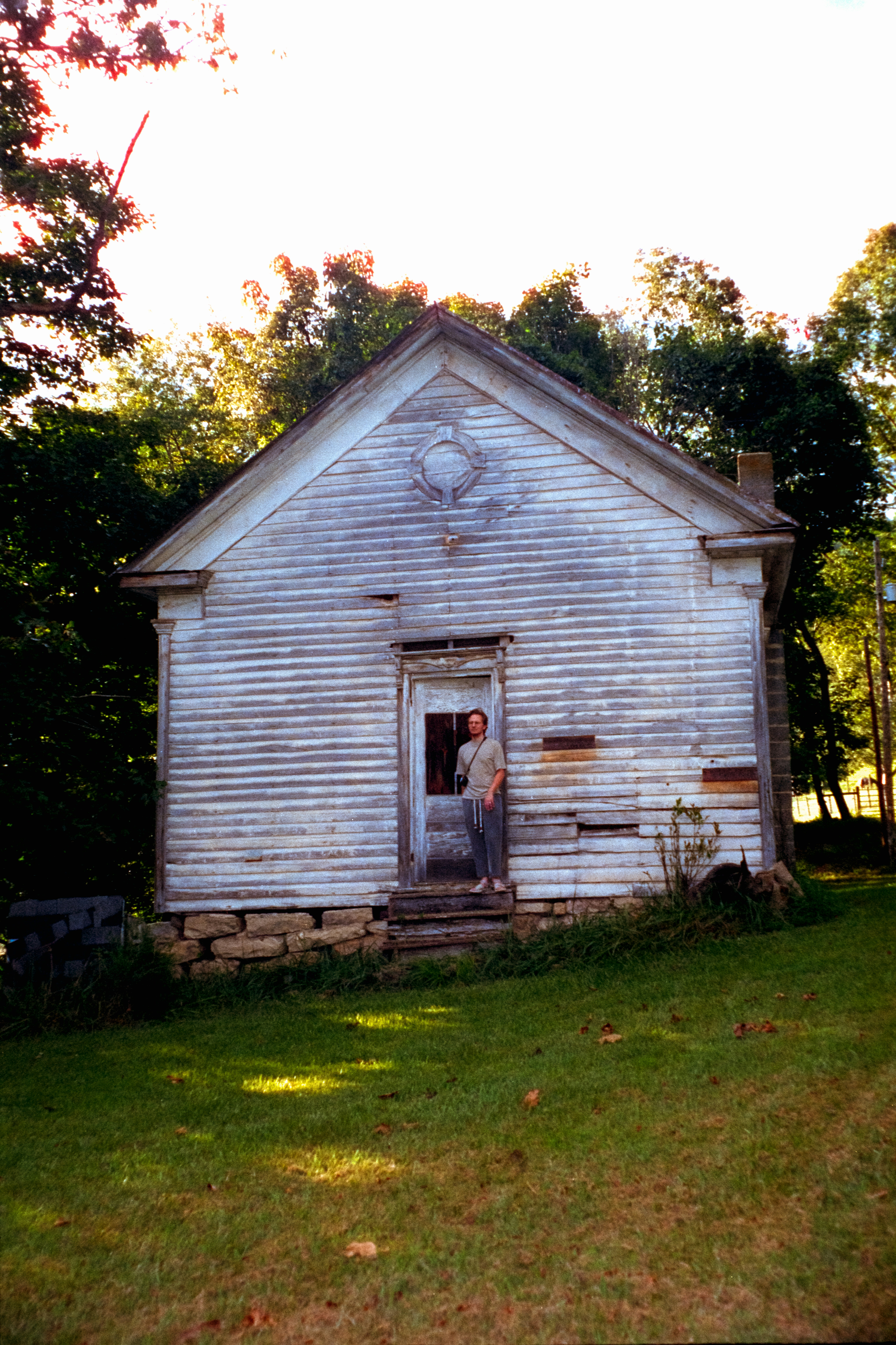 Persona de pie en la puerta de un antiguo edificio de madera.