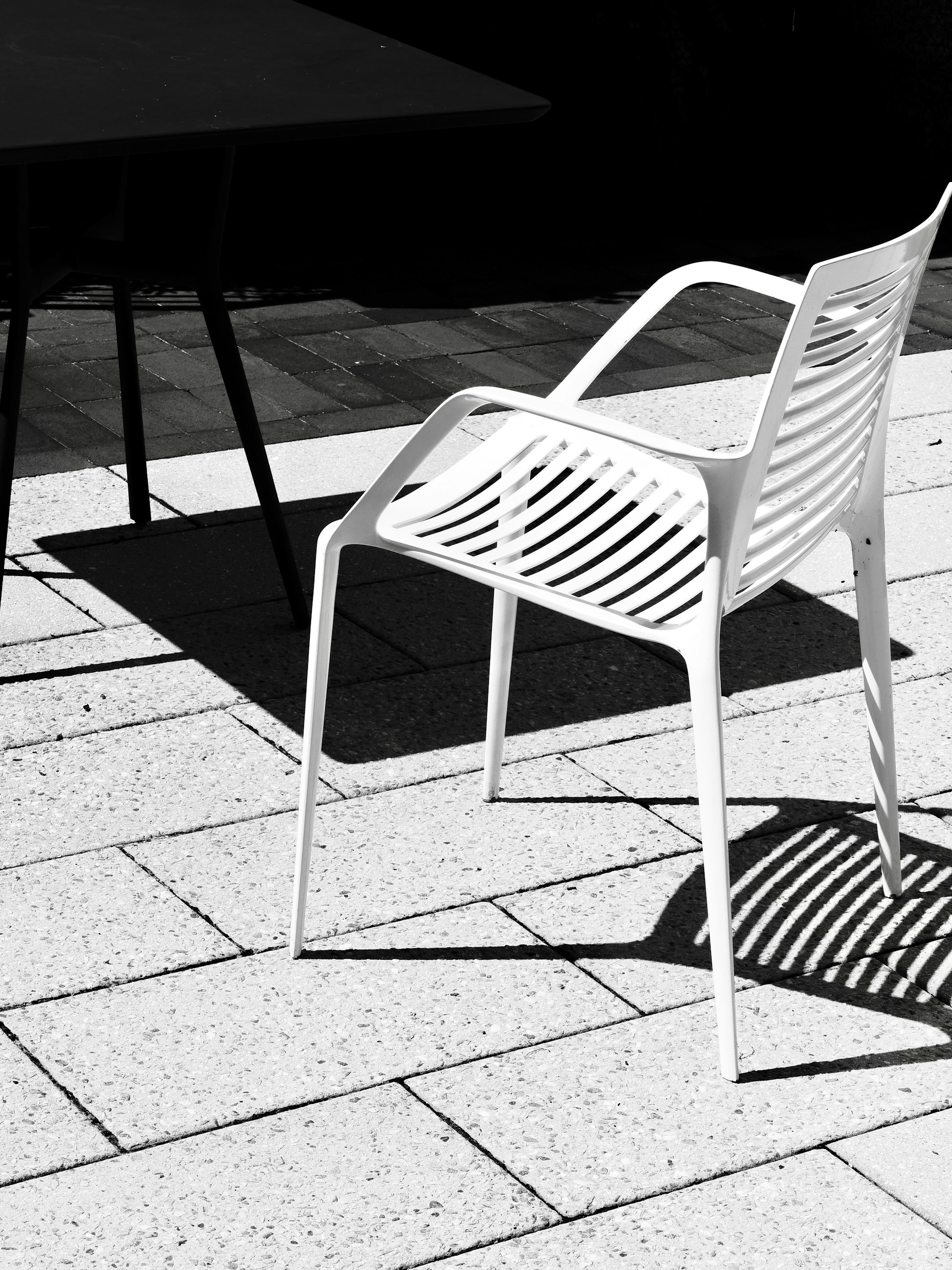 White chair and table casting shadows on patio
