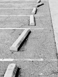 Concrete parking stops line an asphalt lot