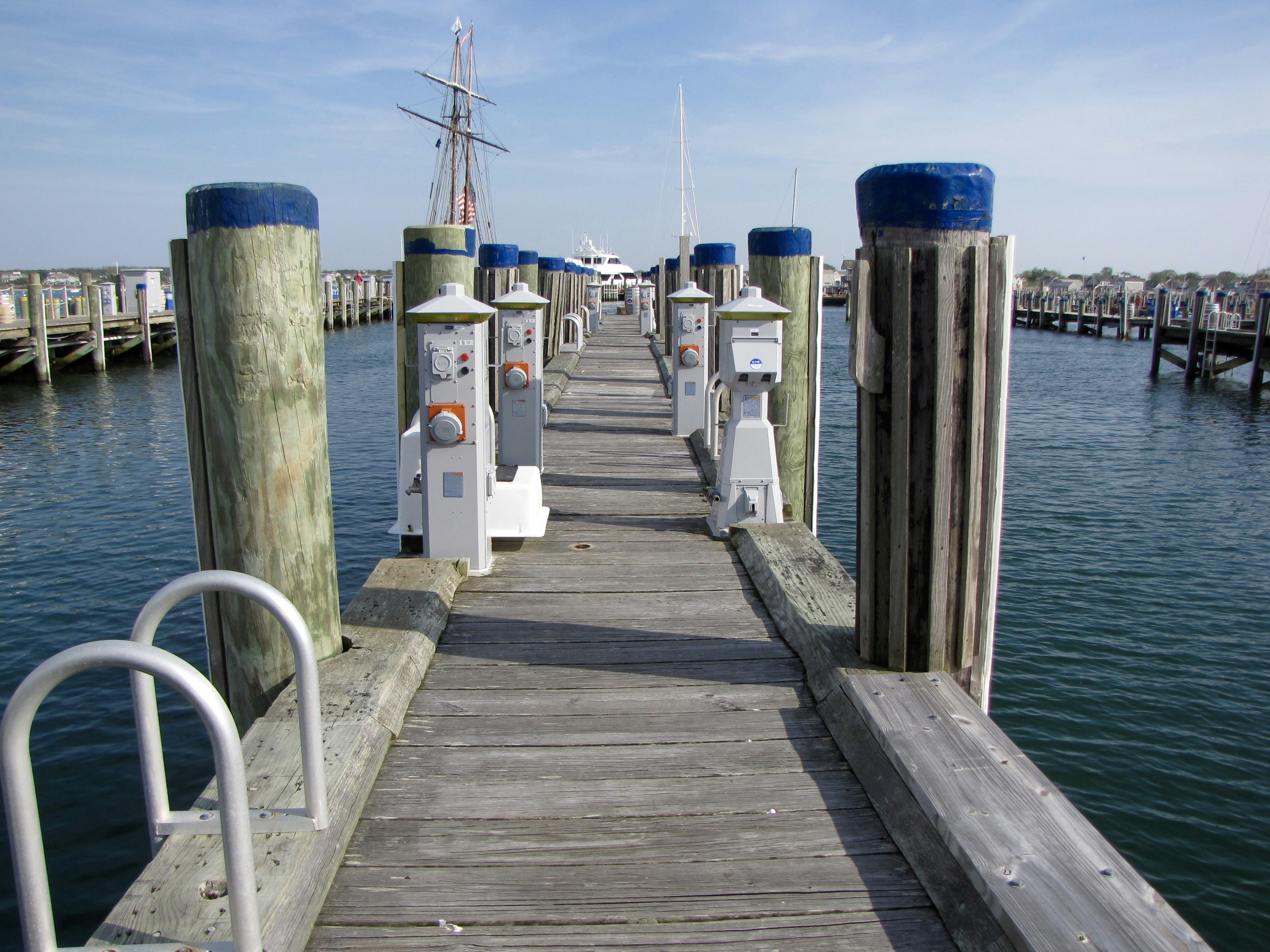 Wooden pier with boats docked in the harbor.