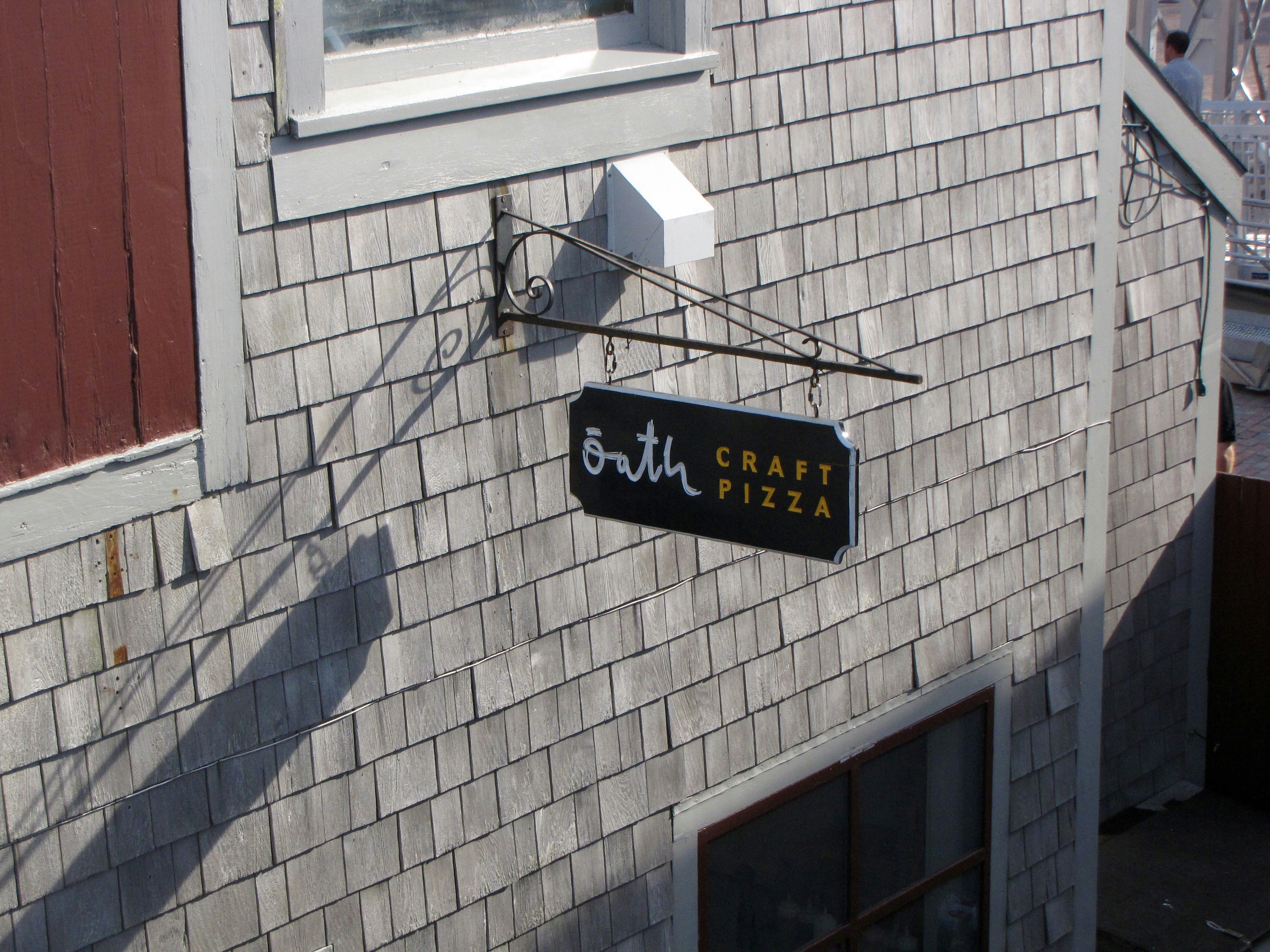 Sign for "bath craft pizza" on shingled wall