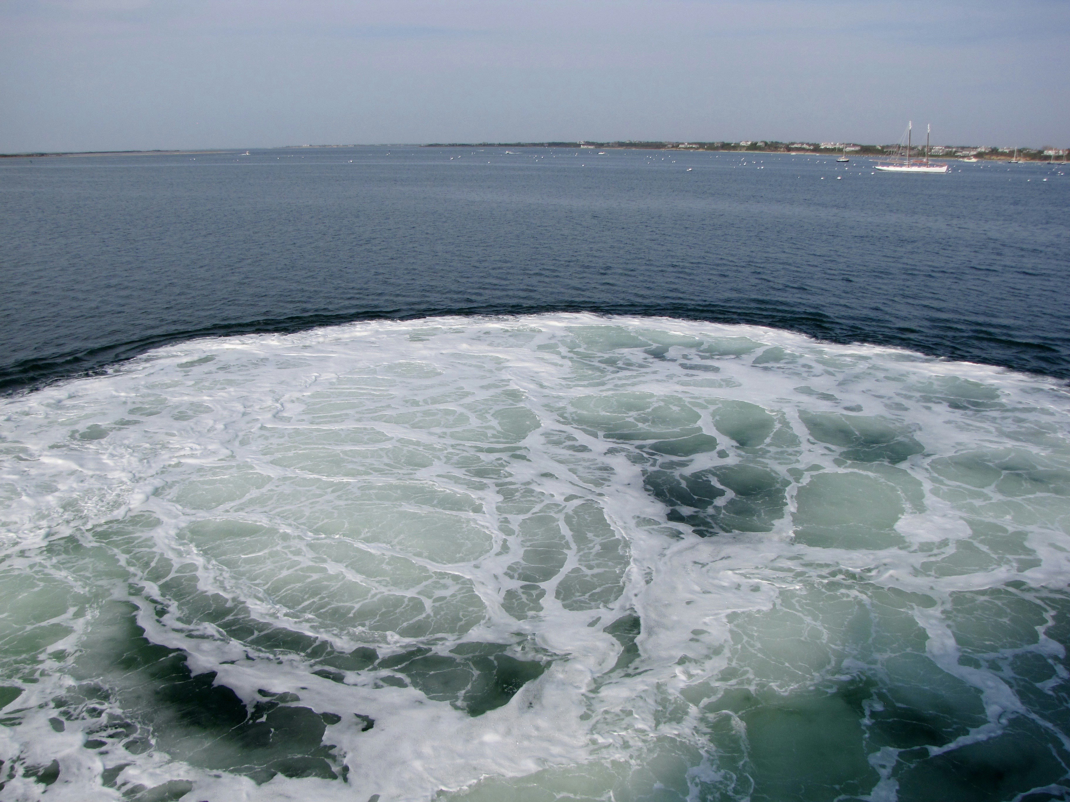 White foam churns in the blue ocean water.