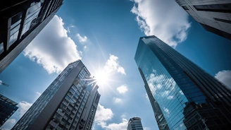 Skyscrapers reaching towards a bright, sunny sky.
