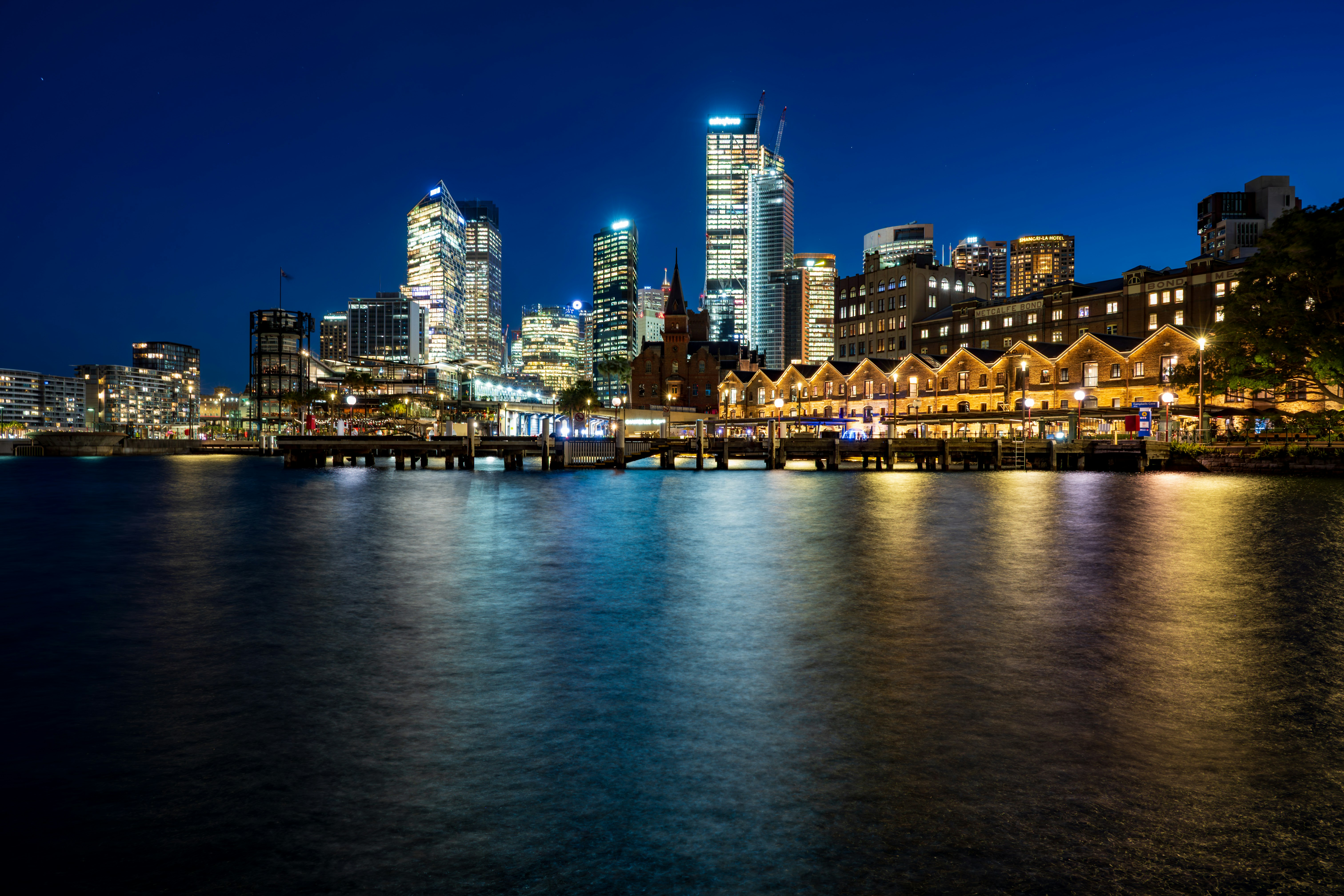 City skyline illuminated at night over the water.
