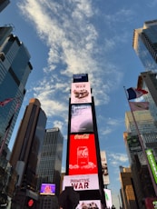 Times square billboards under a cloudy blue sky