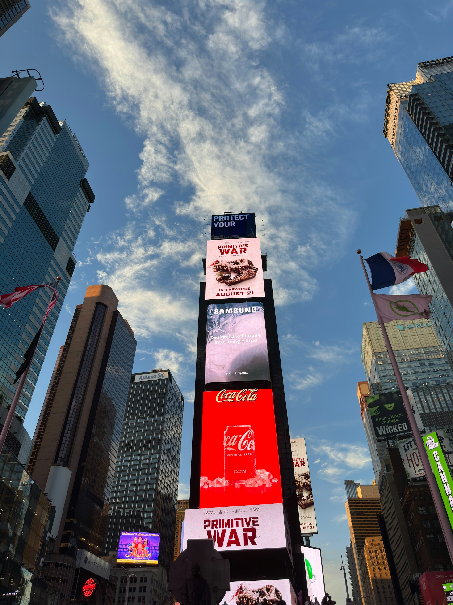 Times square billboards under a cloudy blue sky