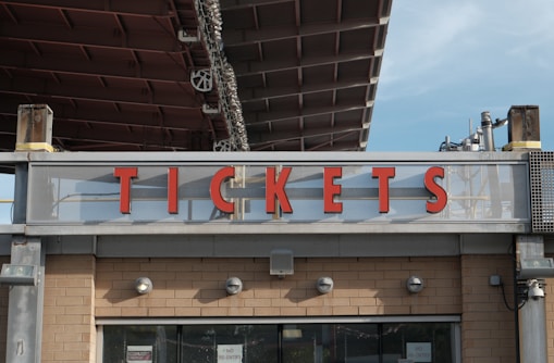 Red letters spell tickets above a building entrance.