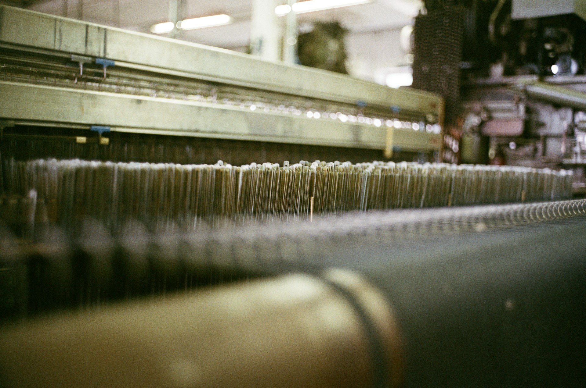 Close-up of threads on a large industrial loom.