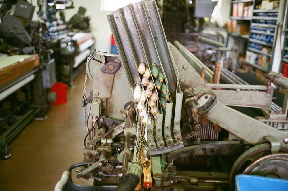 Close-up detail of precision textile machinery and thread spools