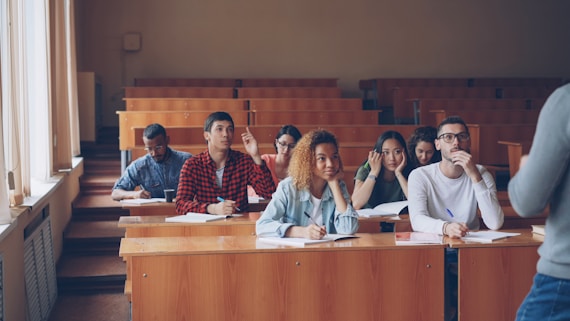 Students raising hands in a lecture hall