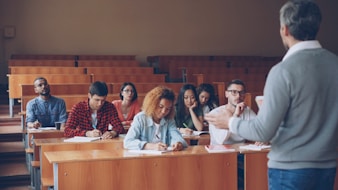Professor teaching students in a lecture hall.