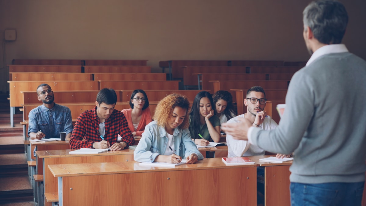 College professor using AI tools while teaching students in a university lecture hall in 2026