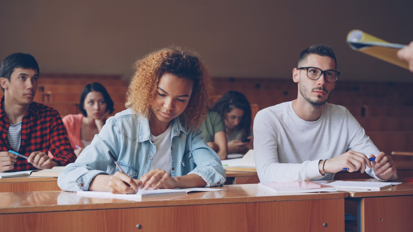 Students taking notes in a university lecture hall