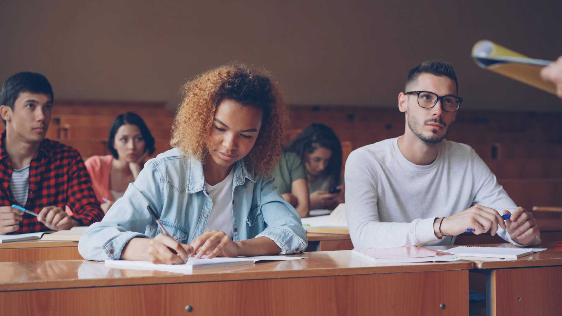Students attentively taking notes in a lecture hall