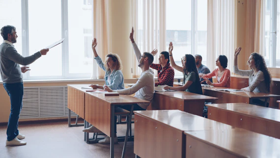 Teacher pointing at students with raised hands