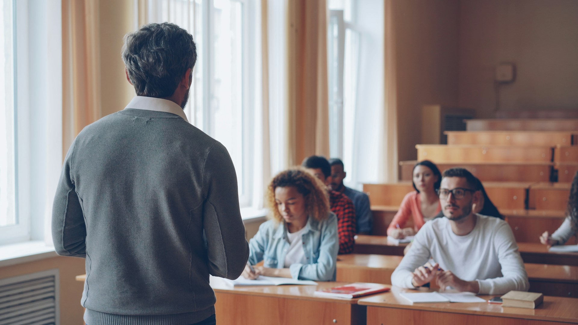 Professor teaching students in a lecture hall.