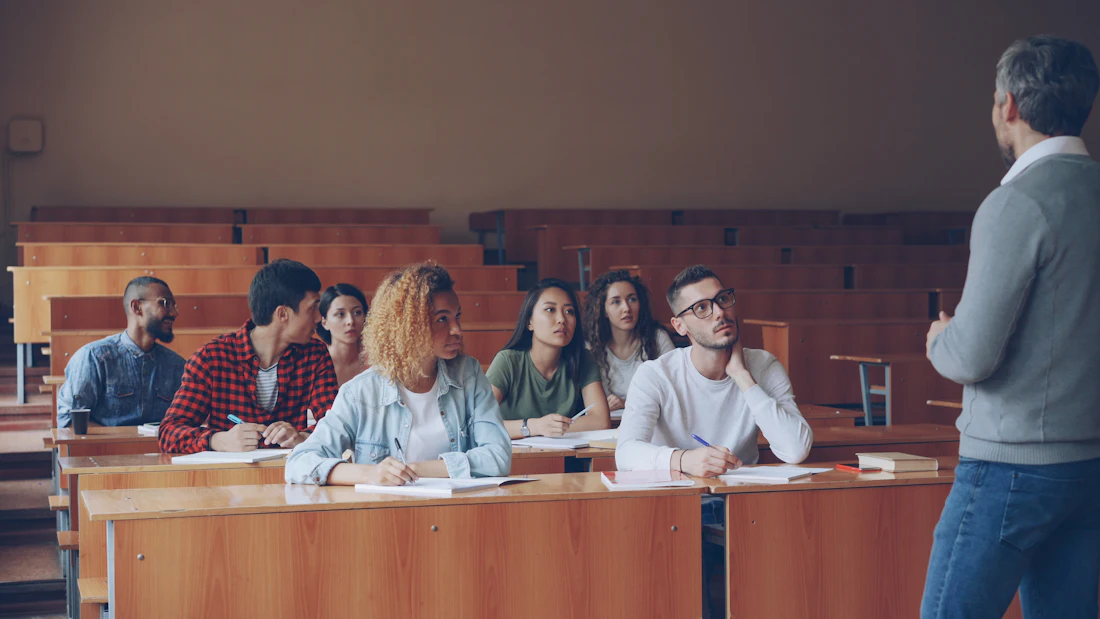 A tutor explaining something to attentive adult students