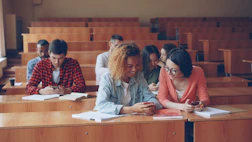 Students looking at phones in a lecture hall.