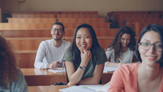 Students smiling in a lecture hall classroom.