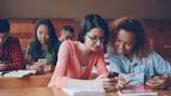 Students looking at phones in a lecture hall.