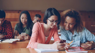Students looking at phones in a lecture hall.