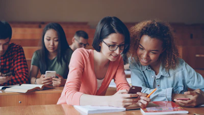 Students looking at phones in a lecture hall.