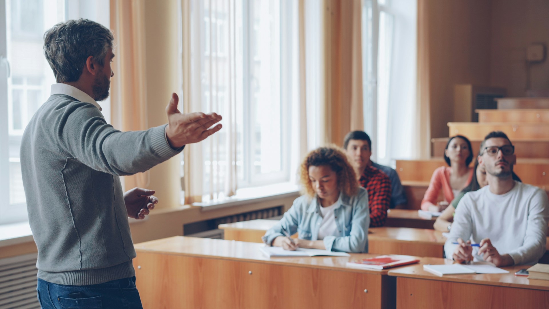 Professor lecturing to students in a lecture hall.