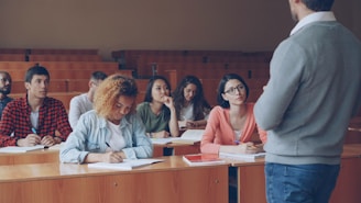 Professor lecturing students in a university lecture hall.