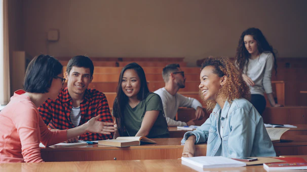 Students talking and laughing in a lecture hall.