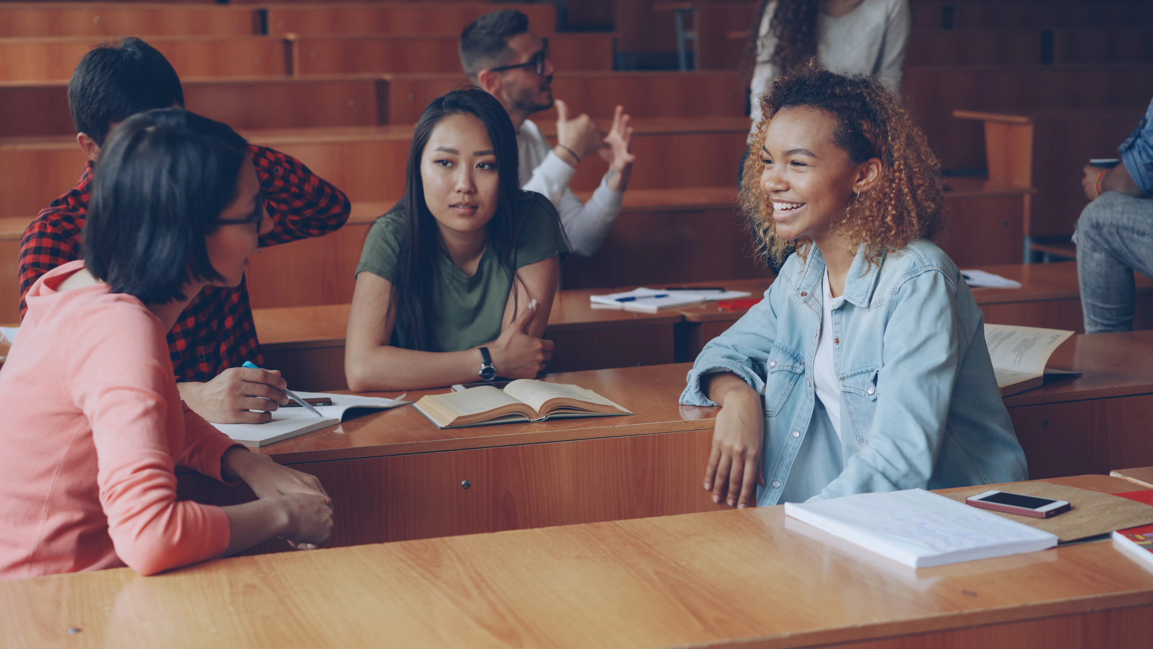Estudantes conversando em um anfiteatro durante a aula