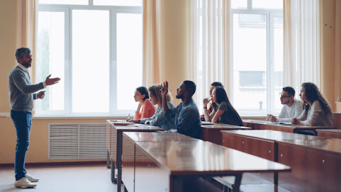 Professor lecturing to students in a classroom setting.