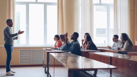 Professor lecturing to students in a classroom setting.