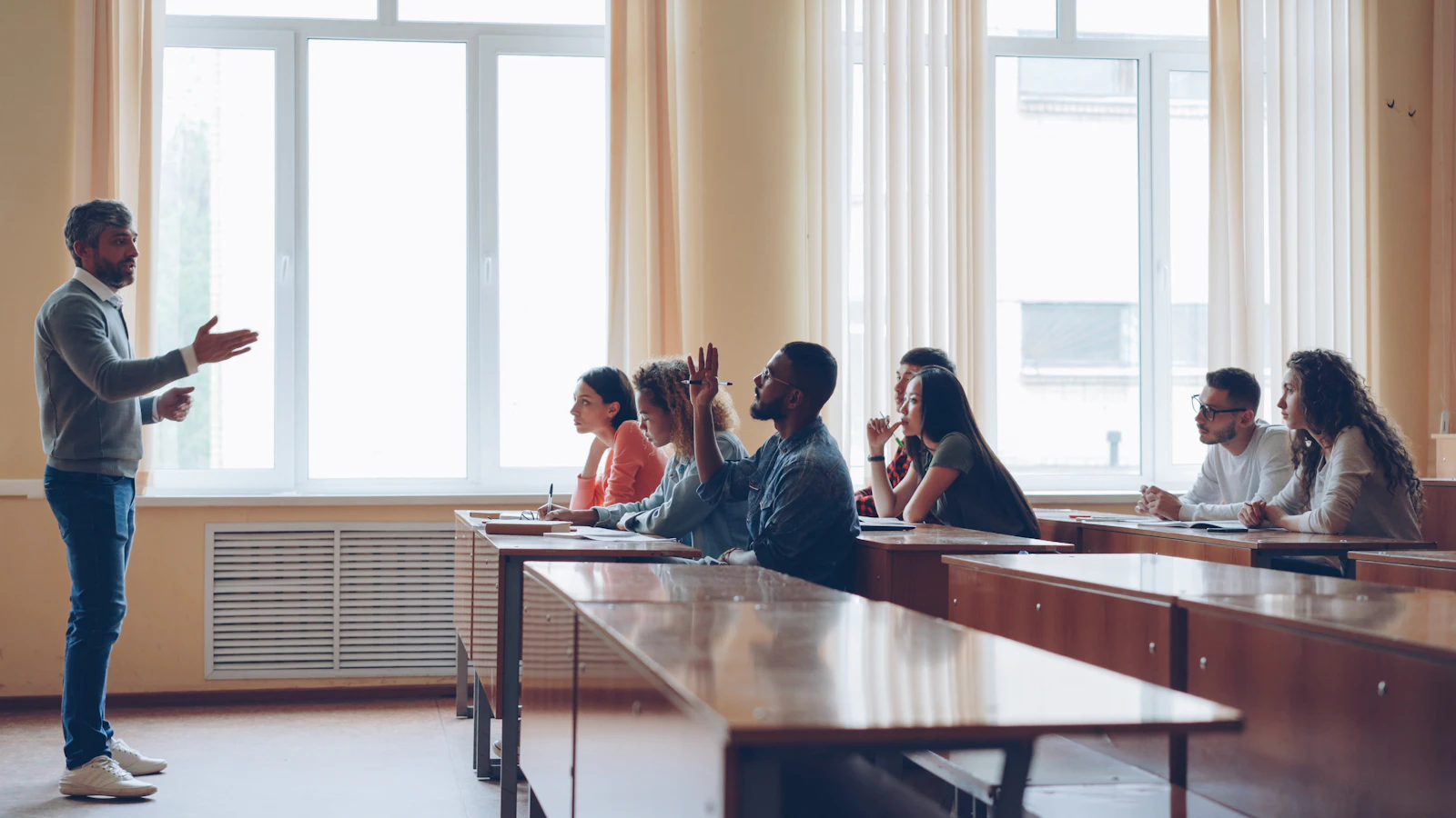 A tutor speaking with students in a lecture setting