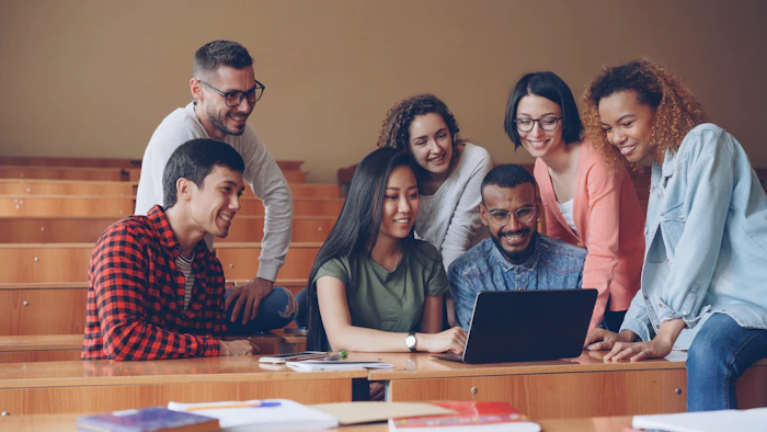 Students studying together around a laptop