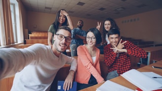 Group of smiling students taking a selfie in classroom
