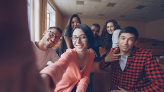 Group of smiling students taking a selfie in classroom