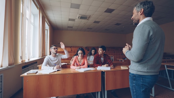 Teacher interacting with students in a classroom setting.