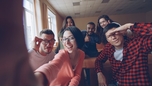 Group of friends taking a selfie in a classroom