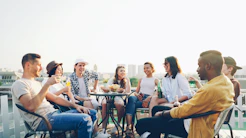 Friends enjoying drinks and snacks on a rooftop.