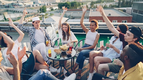 Friends celebrating on a rooftop party with city view.