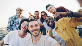 A diverse group of friends taking a selfie outdoors.