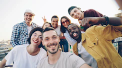 A diverse group of friends taking a selfie outdoors.
