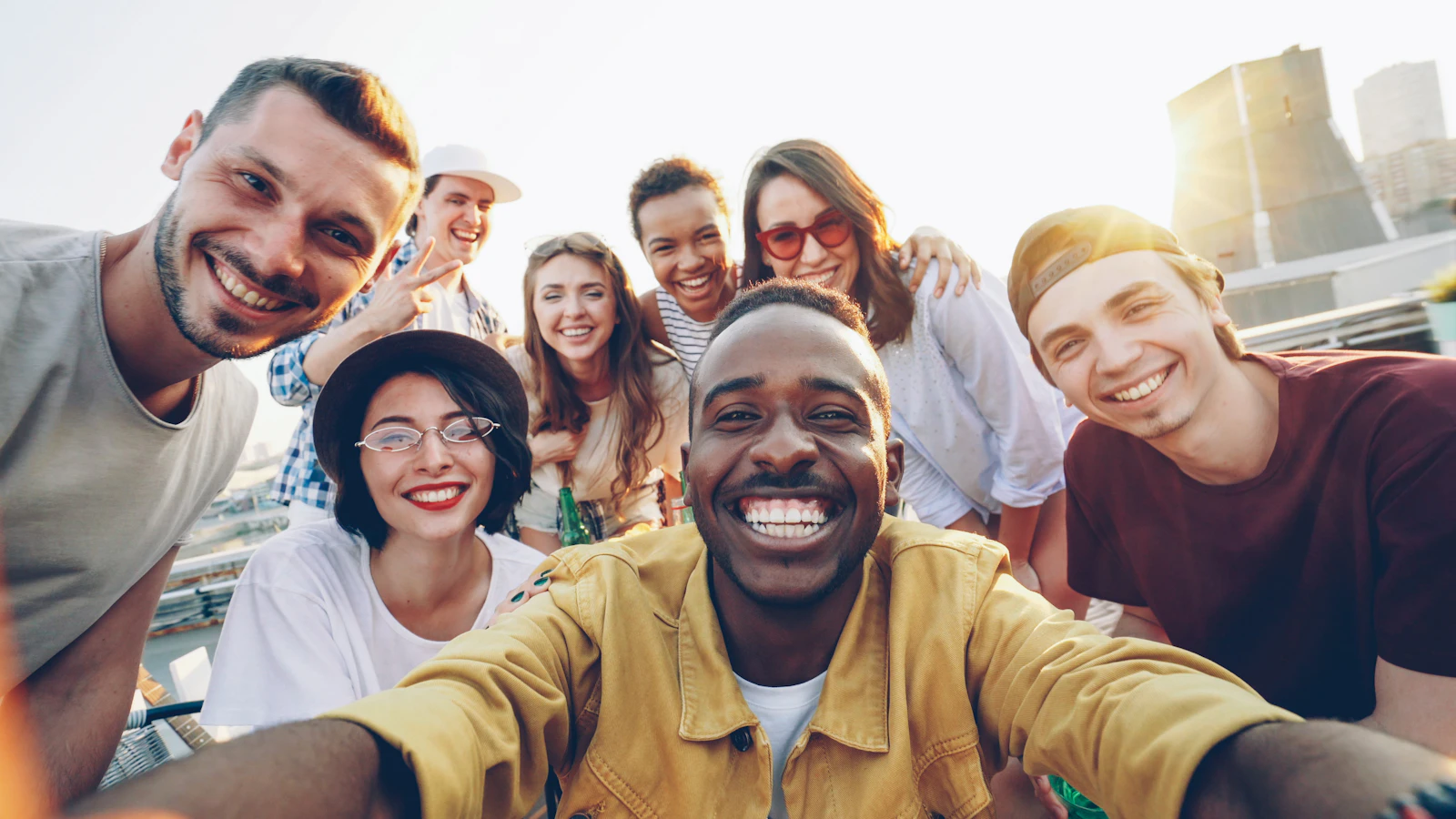 Diverse group of friends including Black people smiling at a rooftop party